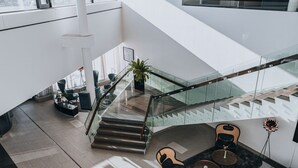 Ein modernes Interieur mit Treppe, Sitzgelegenheit und einem Blumentopf.