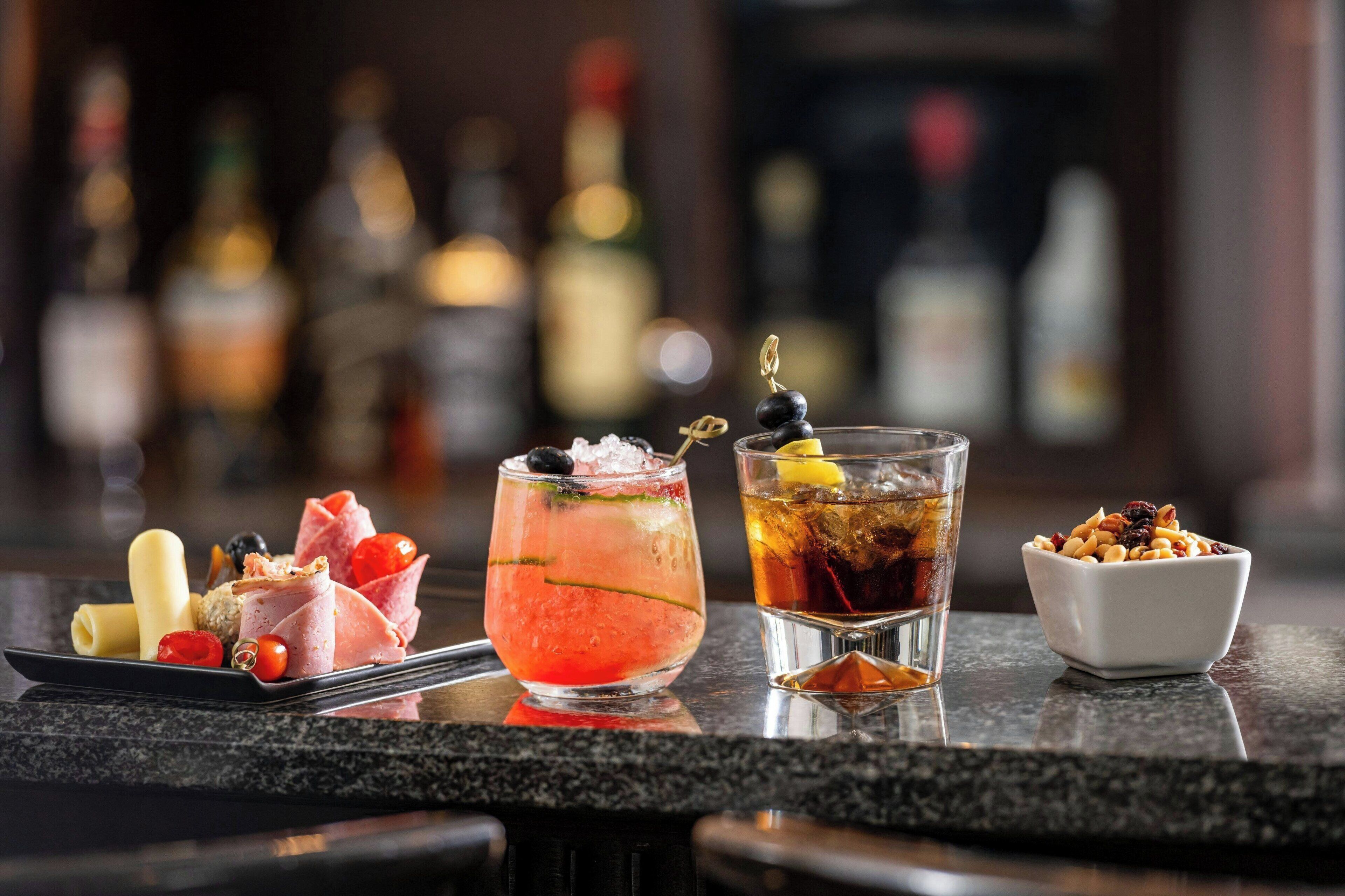 A bar setting with various drinks and snacks.