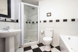 A bathroom with a sink, toilet, shower, and bathtub. - Protea Hotel by Marriott Kimberley (Kimberley)
