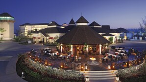 Un patio de hotel con un pabellón central, mobiliario exterior y una fuente de agua.