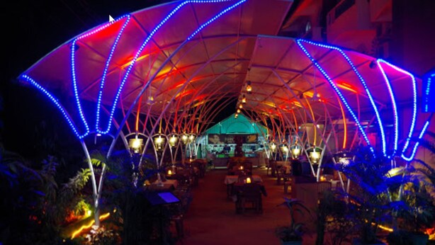 An outdoor dining area with a covered structure and potted plants. - La Ben Resort (Colva)