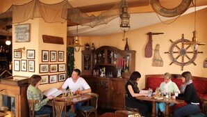 A cozy pub with wooden furniture, a bar area, and maritime decorations. - Hotel Hiddenseer (Stralsund)