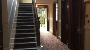 A grand staircase with ornate railings leading to a landing. A potted plant is placed at the top of the stairs. - Edinburghhouse Hotel (Edinburgh)