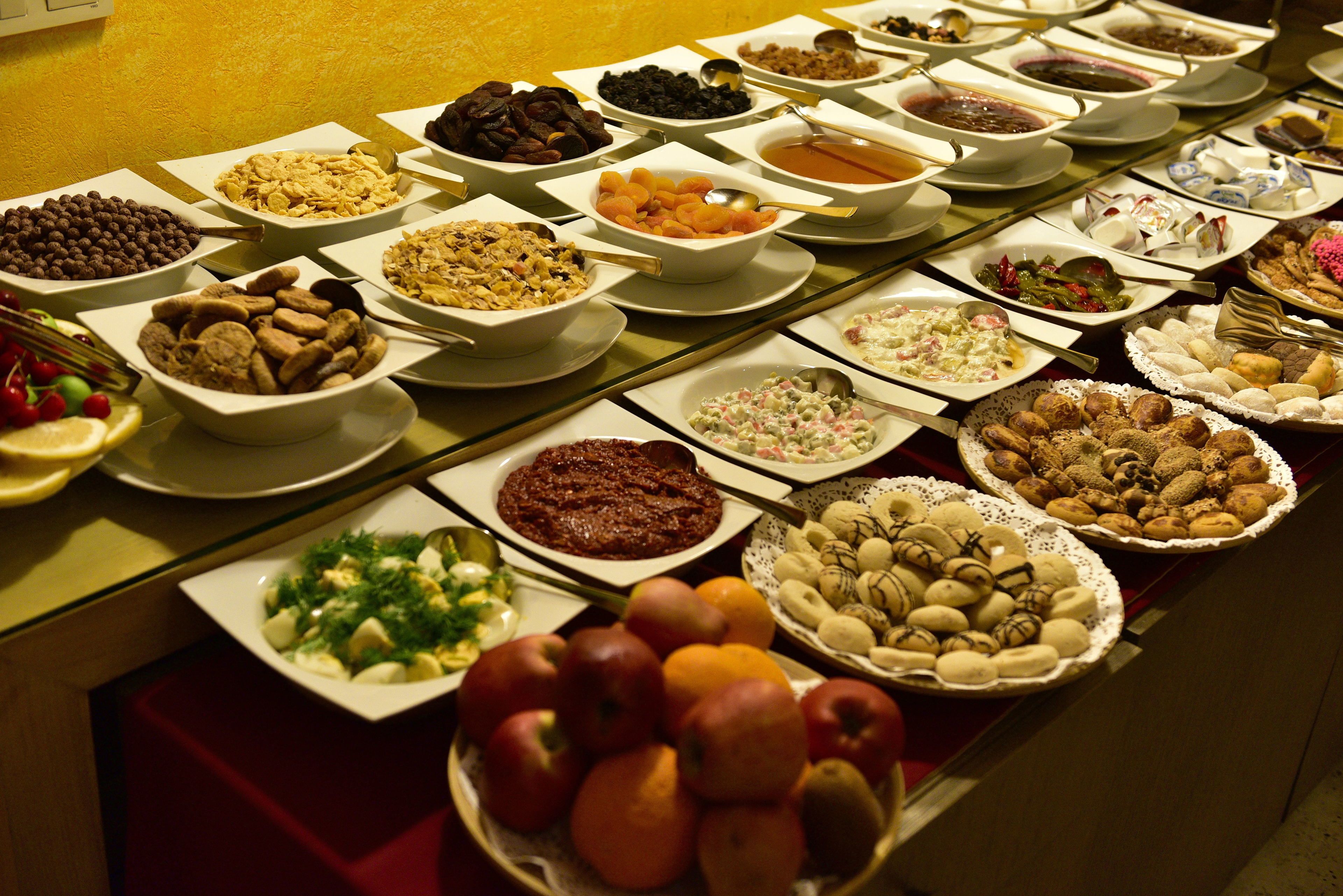 En buffet med forskellige spisemuligheder, herunder frugt, grøntsager og desserter.