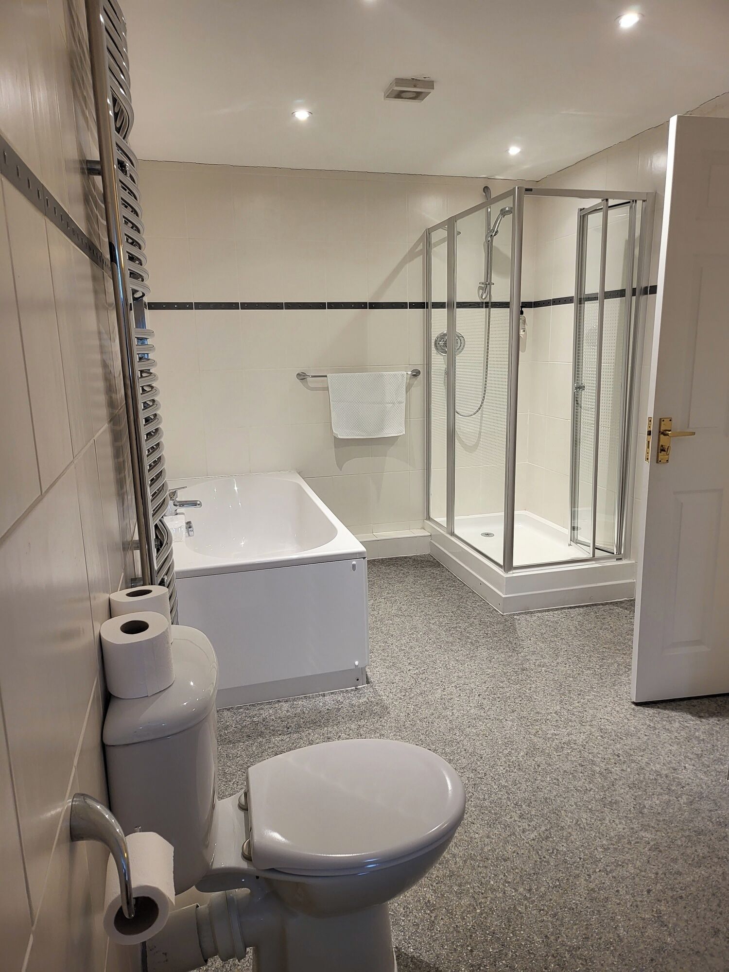 Un bagno moderno con vasca, toilette e doccia vetrata.