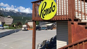 Un panneau Rondo sur une structure en bois, un parking et une montagne en arrière-plan.