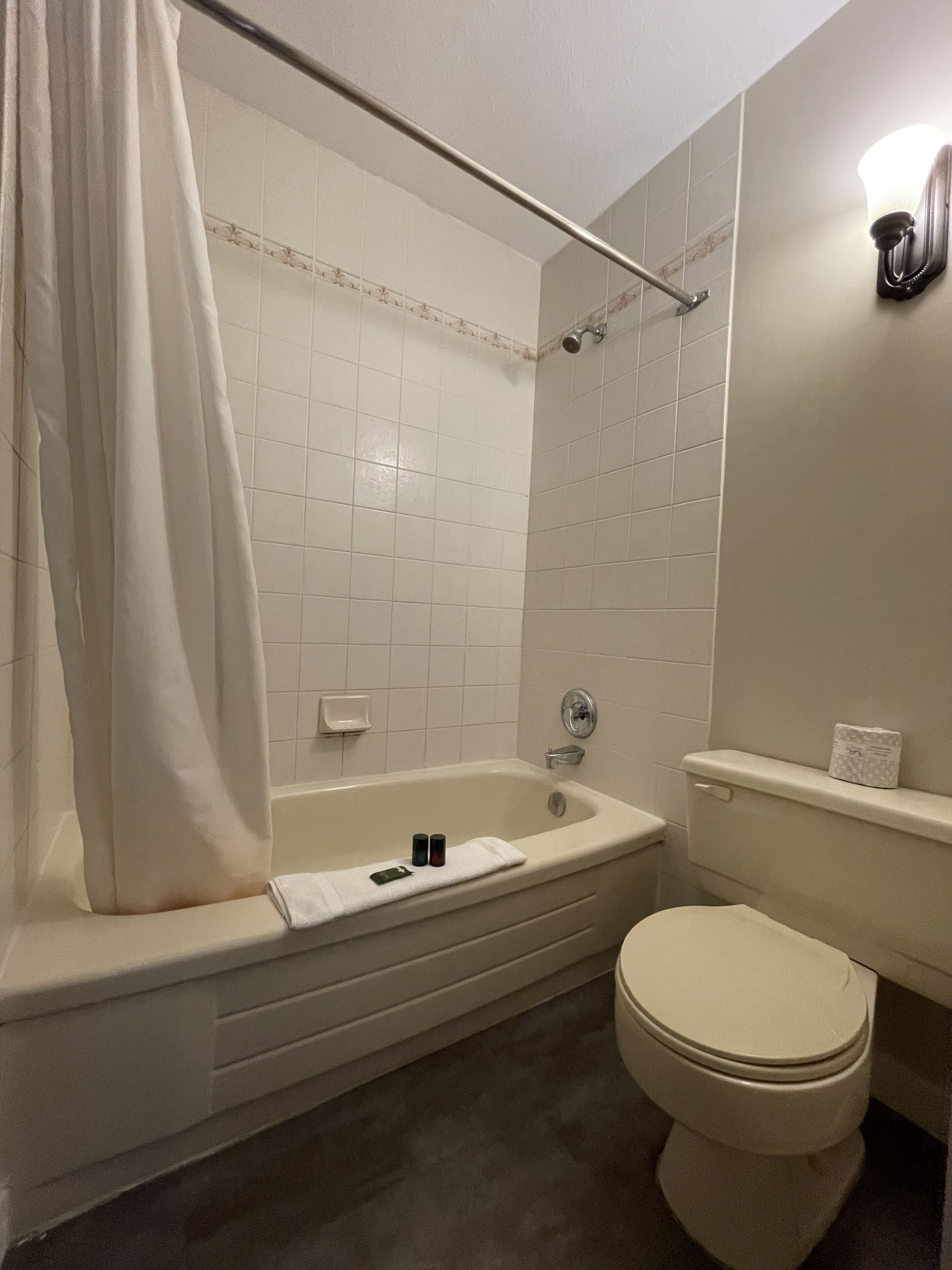 Ein Badezimmer mit Badewanne, Toilette und Duschvorhang.