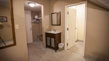 A hotel bathroom with a sink, mirror, and a trash bin.