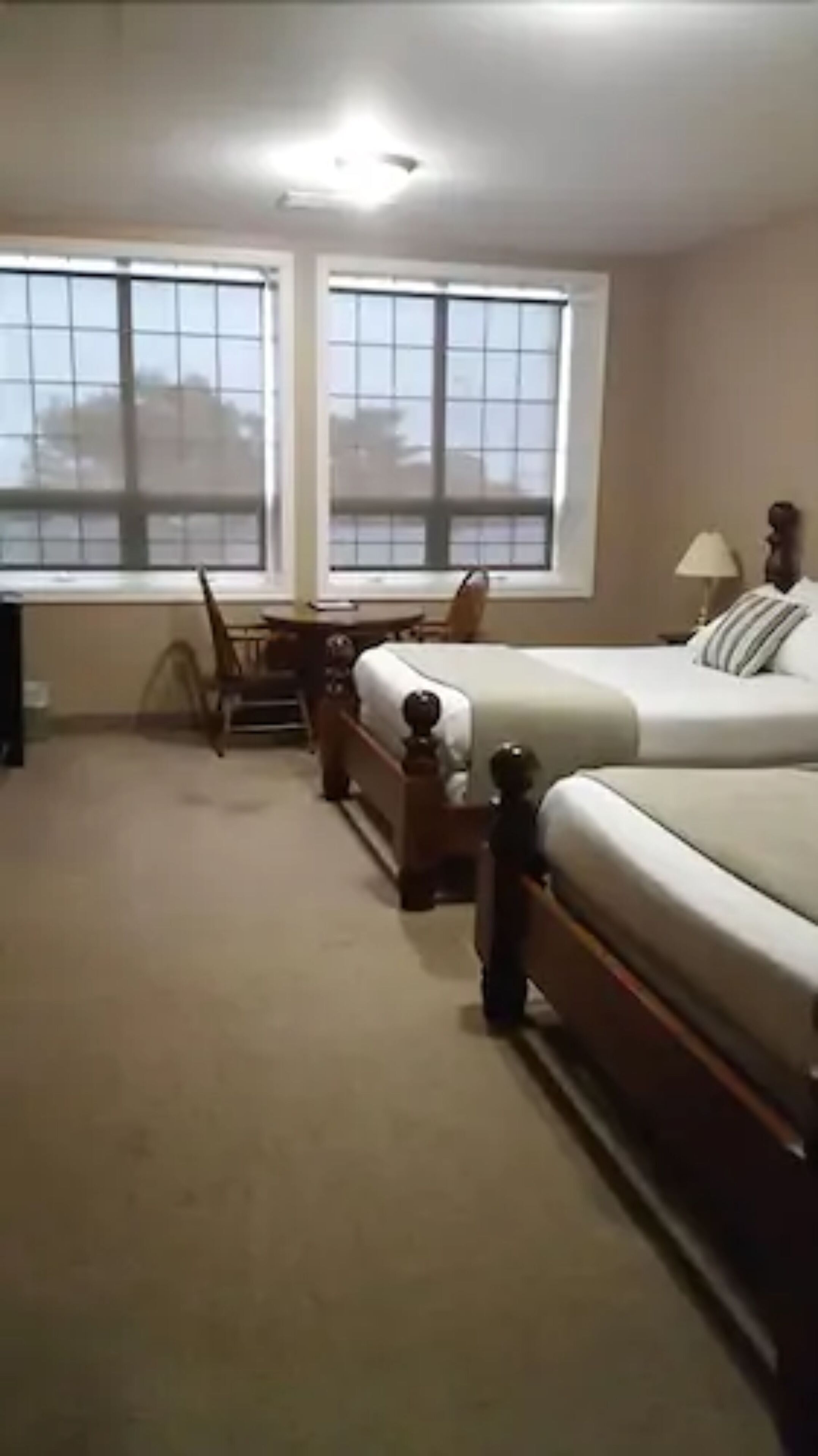 Ein Schlafzimmer mit einem großen Bett, einem Schreibtisch und zwei Fenstern.