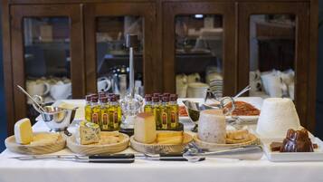 Una mesa de buffet con una variedad de quesos, untables y aderezos.