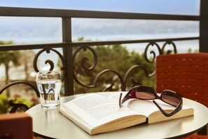 An open book on a table with a pair of glasses and a glass of water. - Geranio au Lac (Muralto)