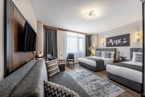 Habitación cuádruple Deluxe | 1 habitación, minibar, caja de seguridad en la habitación y escritorio