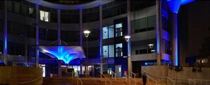 A multi-level building with a central atrium, staircases, and a large illuminated structure.