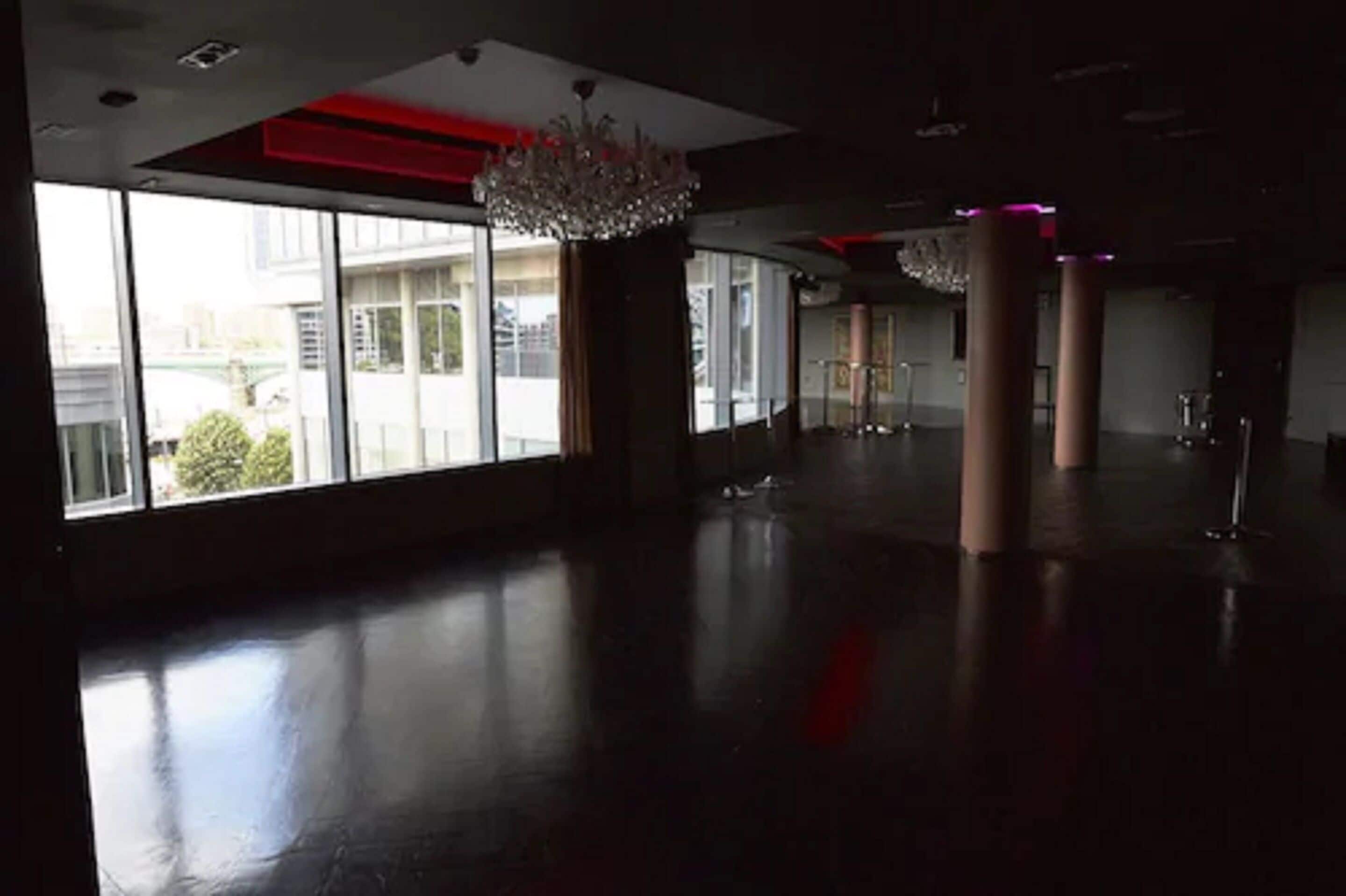 A spacious lobby with large windows, a chandelier, and a modern design.