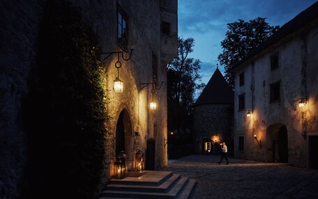 A historic building with stone walls, arched doorways, and a cobblestone courtyard.