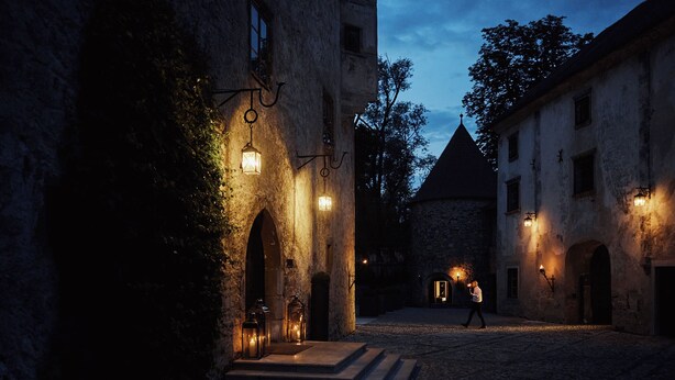 A historic building with stone walls, arched doorways, and a cobblestone courtyard. - Hotel Grad Otocec Relais & Châteaux (Novo Mesto)