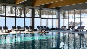 A swimming pool with sun loungers and large windows overlooking a snowy landscape. - Hotel Grad Otocec Relais & Châteaux (Novo Mesto)