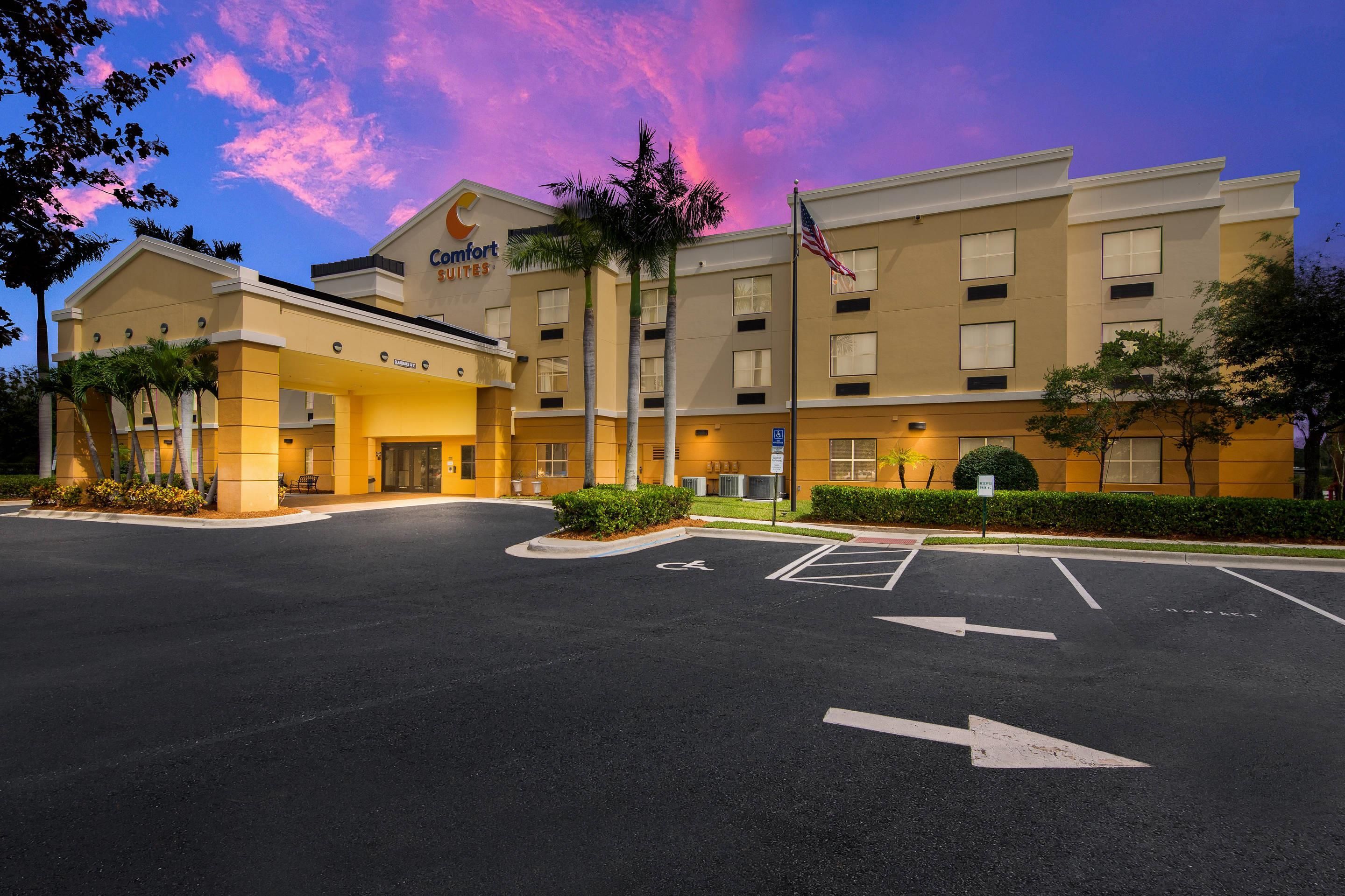 Hotel Comfort Suites con cielo despejado y estacionamiento al frente.