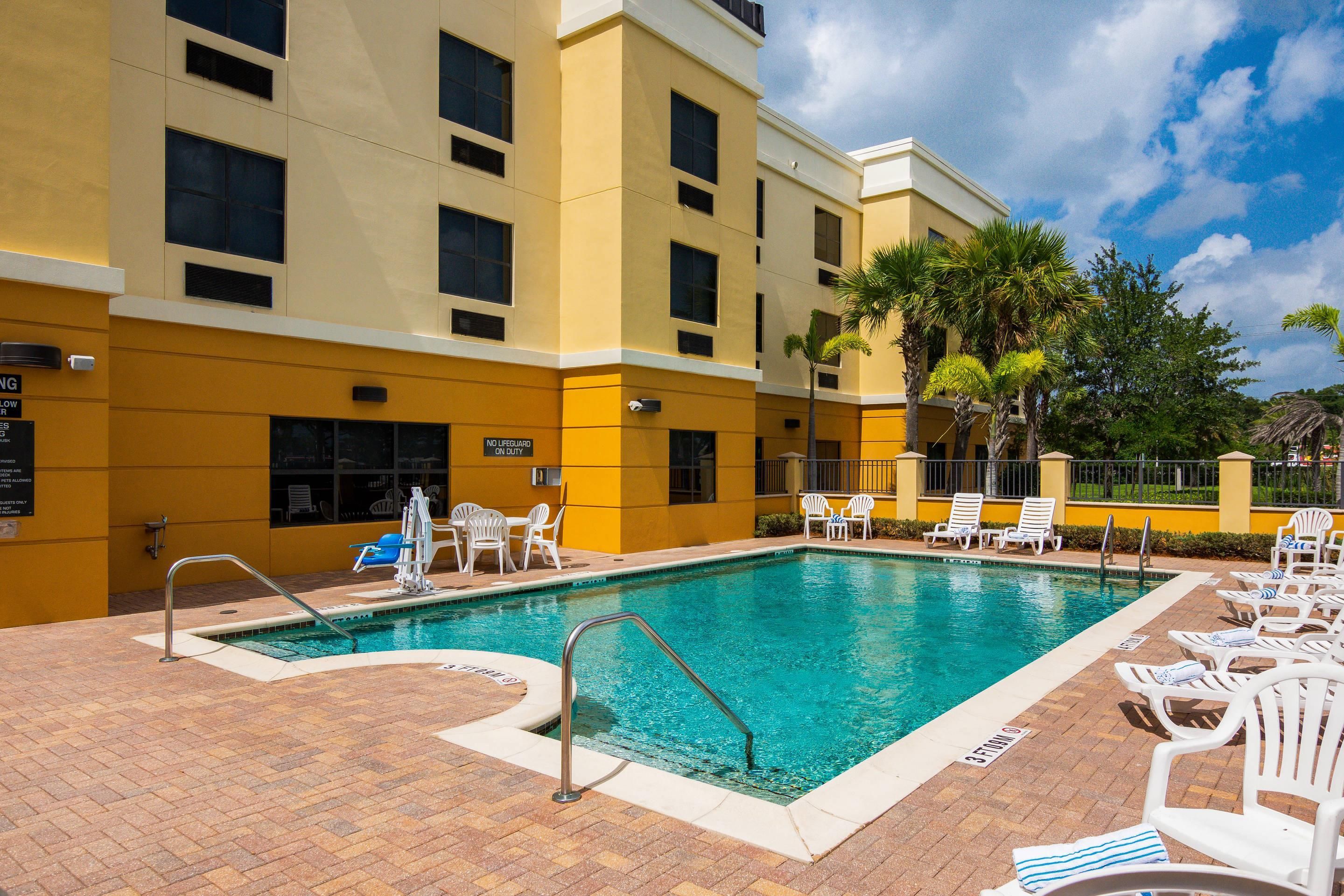 A swimming pool with lounge chairs and a lifeguard stand.
