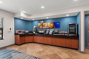 Un bar pour prendre le petit-déjeuner, équipé d’une machine à café, d’un four à commande tactile et d’un réfrigérateur-vitrine.