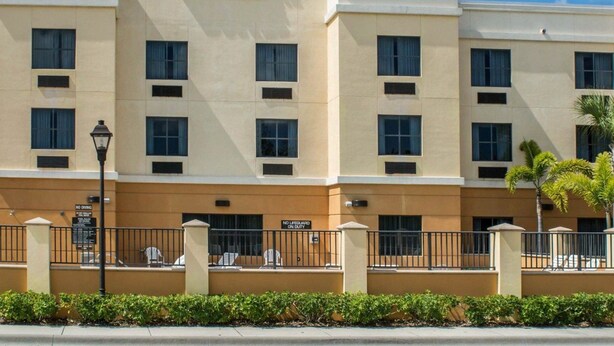 A hotel with a beige facade, multiple windows, and a sign reading "Comfort Suites."