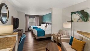 A hotel room with a large bed, two bedside tables, a desk, a chair, a TV, and a painting on the wall.