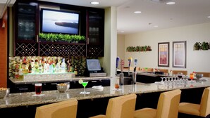 Eine Bar mit Fernseher, Theke und Sitzgelegenheiten.