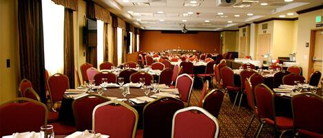 Une salle de conférence dotée de plusieurs tables et chaises, ainsi que de plaques nominatives et de verres.