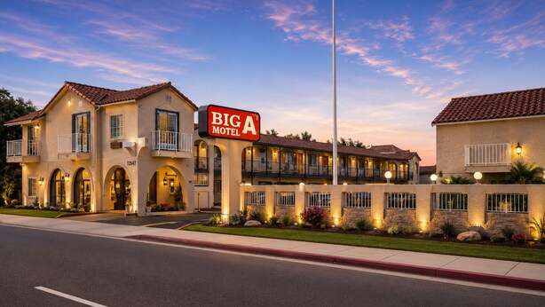 A motel with a prominent sign, multiple balconies, and a well-lit entrance. - Big A Motel & Suites Near Disneyland Orange County (Orange)