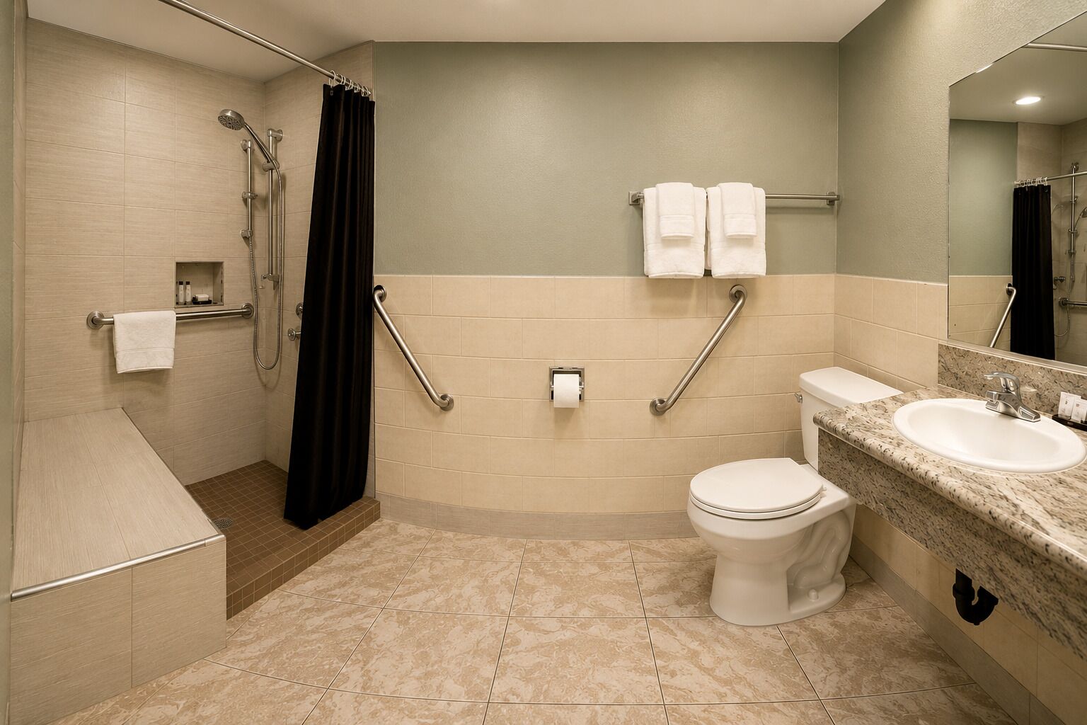 Een badkamer met douche, toilet, wastafel, greepstangen en een handdoekrek.