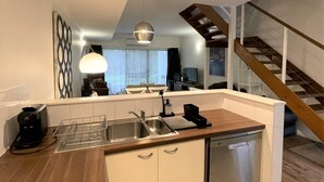 A modern kitchen with a wooden countertop, stainless steel appliances, and a built-in dishwasher.