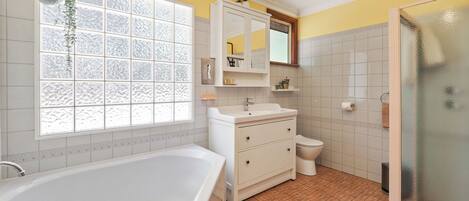 A bathroom with a bathtub, toilet, and shower.