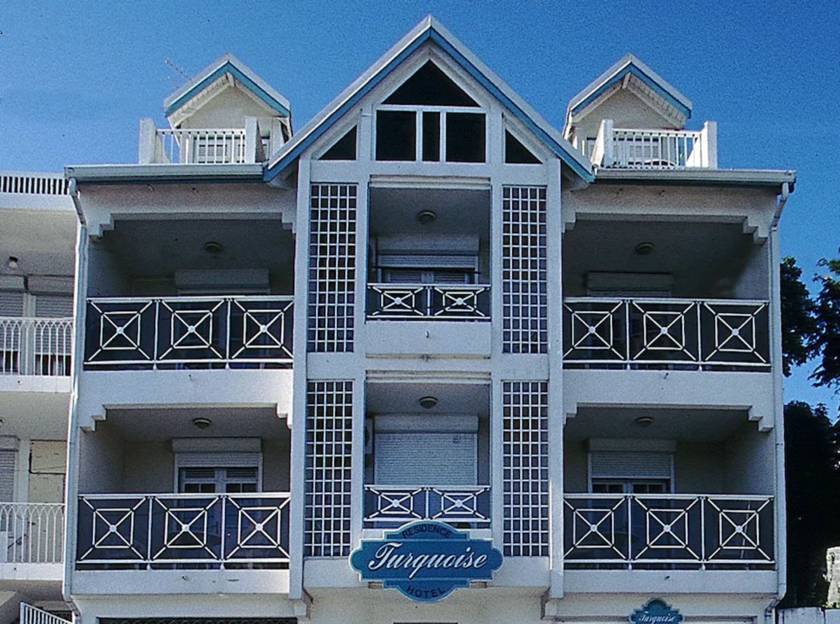 A multi-story hotel with a central atrium, balconies on each floor, and a sign reading "Turquoise Hotel".