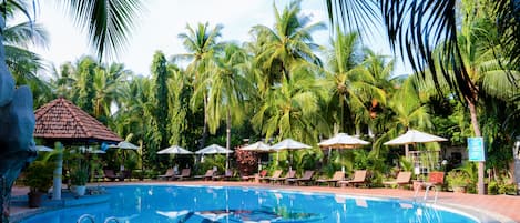 Una piscina al aire libre, sombrillas, sillones reclinables de piscina