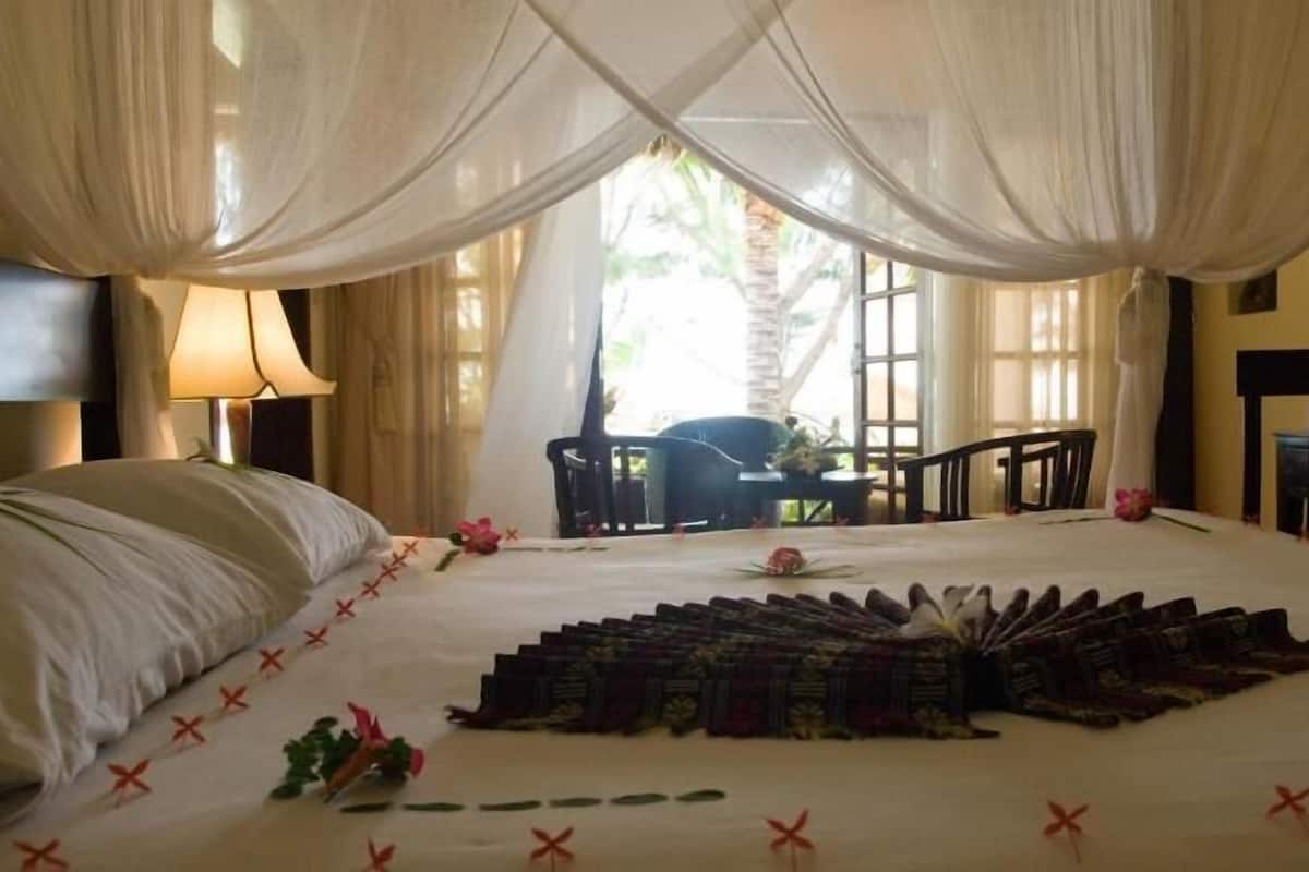Quarto de hotel com cama, escrivaninha e cadeira.