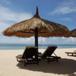 Aan een privéstrand, wit zand, ligstoelen, parasols