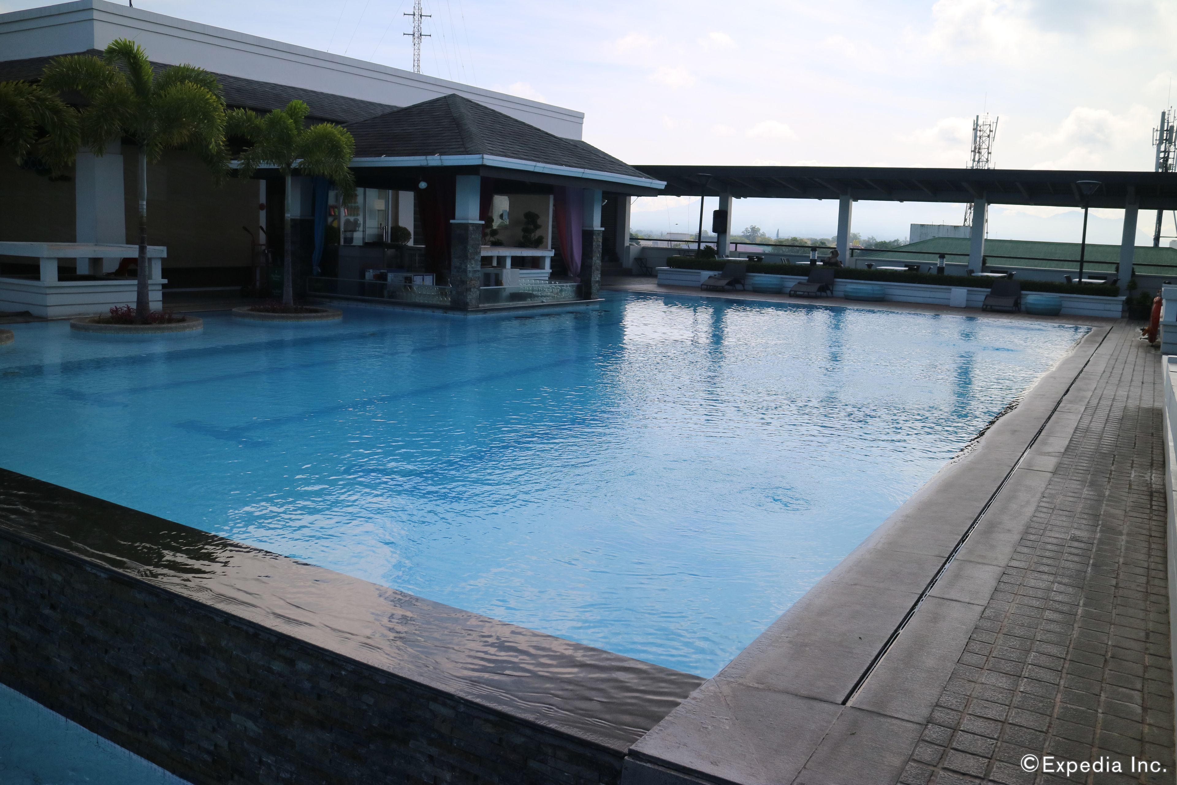 Una piscina al aire libre, tumbonas