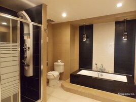 Un baño moderno con cabina de ducha, inodoro y una bañera grande.