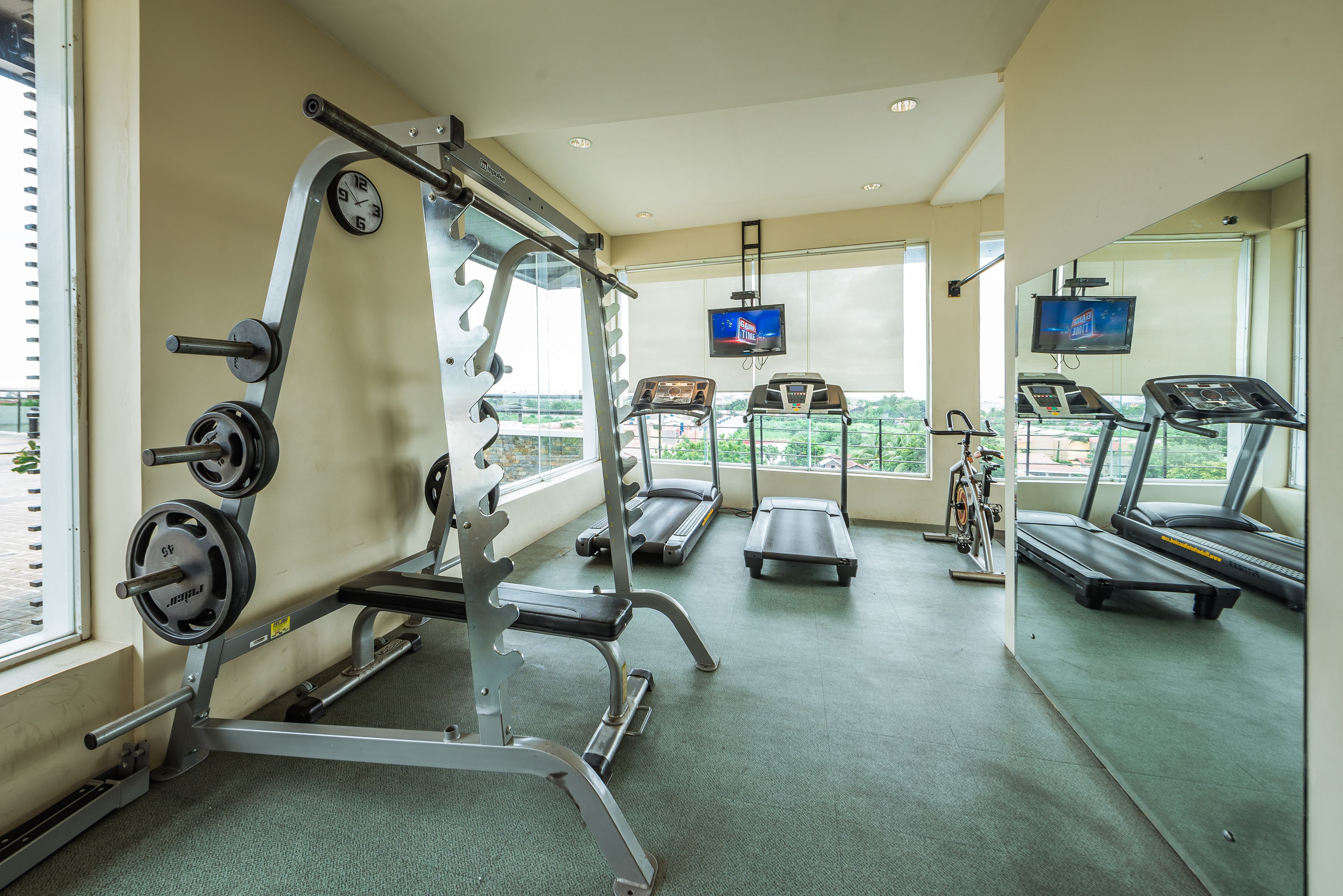A gym with treadmills, a weight bench, and a stationary bike.