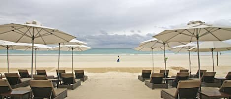 På stranden, vit sandstrand, solstolar och strandhanddukar