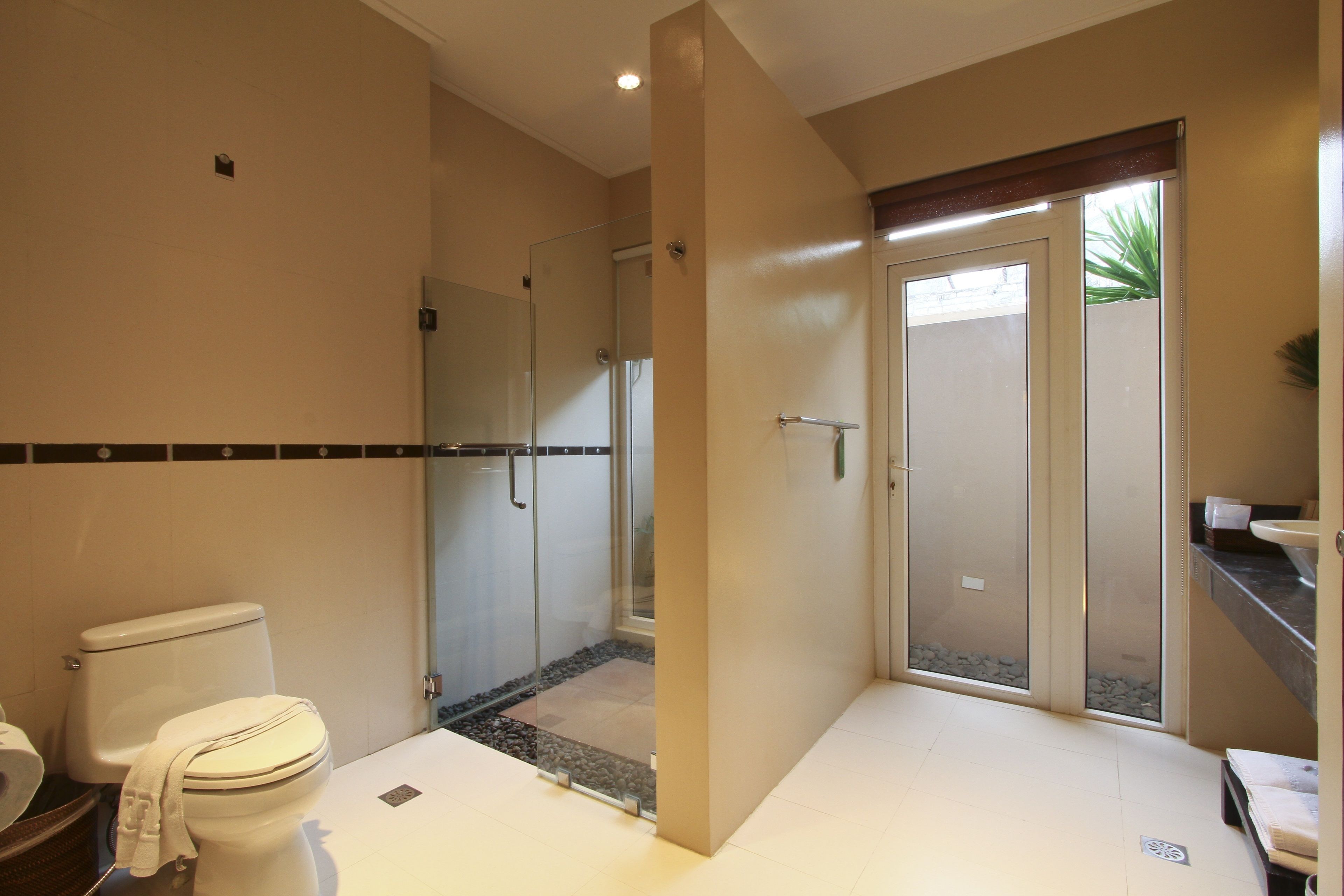 A modern bathroom with a toilet, shower, and glass-enclosed shower area.