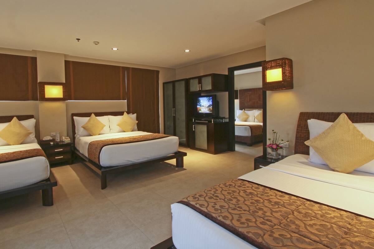 Una habitación de hotel con dos camas, televisión y un minibar.