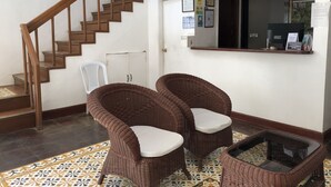Una escalera conduce a un rellano con una recepción y un espejo sobre ella.