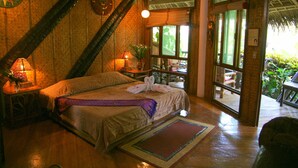 A cozy bedroom with a bed, bedside lamps, and a view of the outdoors. - Nigi Nigi Nu Noos “e” Nu Nu Noos (Boracay Island)