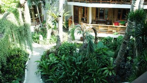 A lush indoor garden with a pathway leading to a wooden deck area. - Nigi Nigi Nu Noos “e” Nu Nu Noos (Boracay Island)