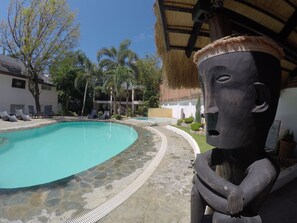Una piscina al aire libre, sillones reclinables de piscina