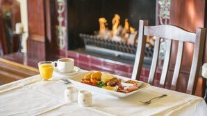 Una mesa de desayuno con un plato de comida, un vaso de jugo de naranja y una taza de café.