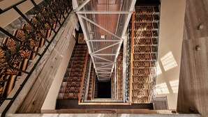 A staircase with ornate railings and patterned wall designs. - Hotel President (Bielsko-Biala)