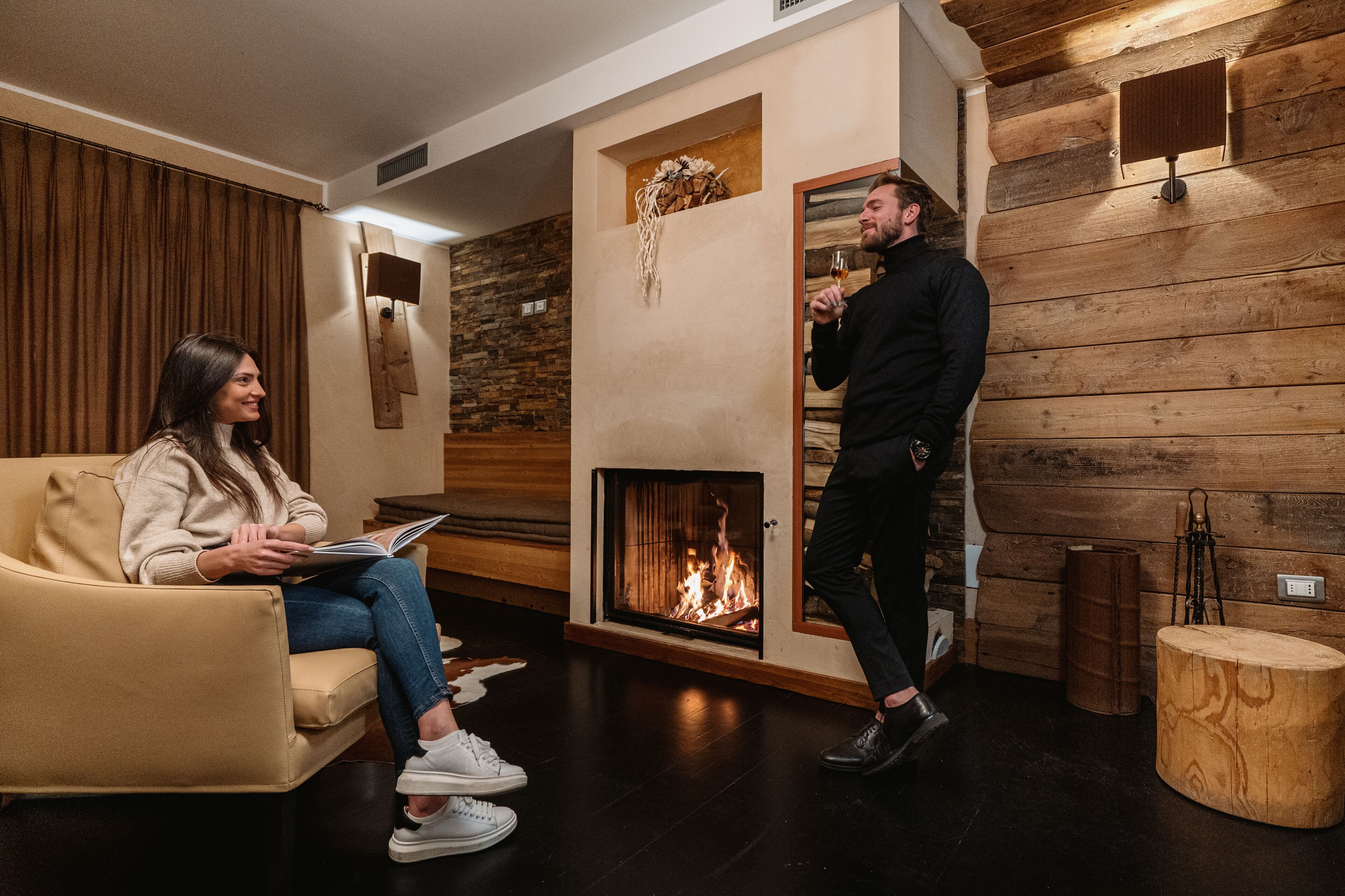 A cozy room with a fireplace, a sofa, and a wooden accent wall.