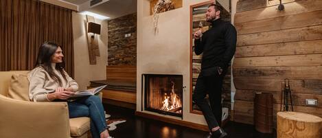 A cozy room with a fireplace, a sofa, and a wooden accent wall.
